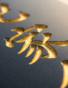 黒御影石の墓誌（縦長の石板）に丁寧に彫刻された戒名の漢字